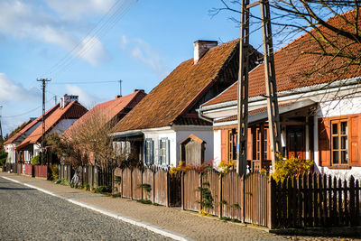 Houses by street against sky in city