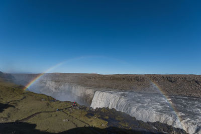 Scenic view of rainbow over waterfall