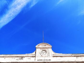 Low angle view of clock tower against blue sky