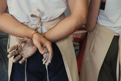 Midsection of couple holding hands