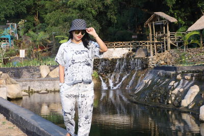 Full length of woman standing by lake