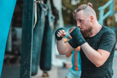 Young man practicing boxing while standing outdoors