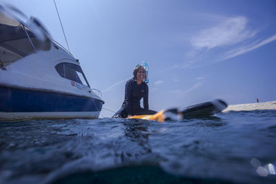 Man on boat in sea against sky