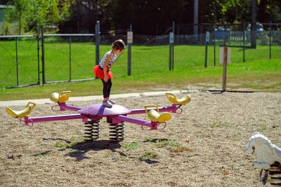 Girl standing on ride in park