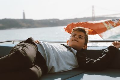 Rear view of friends lying on boat