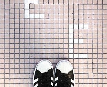 Low section of person standing on tiled floor