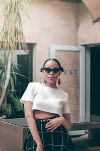 Portrait of young woman wearing sunglasses standing outdoors