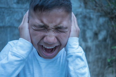 Close-up of teenage boy screaming