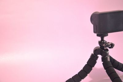 Close-up of security camera against pink background