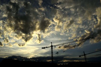 Low angle view of silhouette electricity pylon against sky