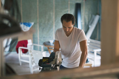 Man using circular saw in during house renovation