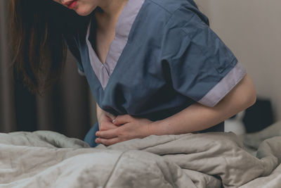 Midsection of doctor examining patient at home