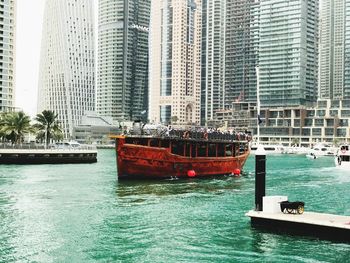 Boats in sea against buildings in city