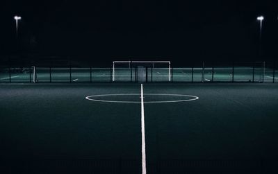 Empty benches on soccer field at night