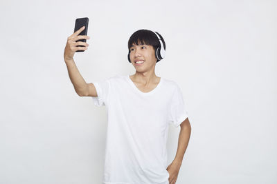 Mid adult man using mobile phone against white background