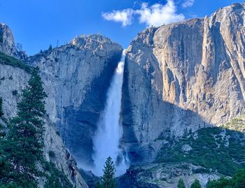 Scenic view of waterfall against sky