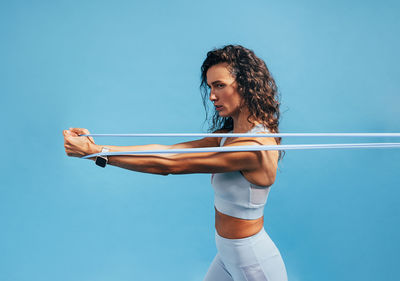 Woman stretching resistance band in studio