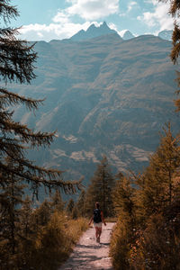 Rear view of people on mountain against sky