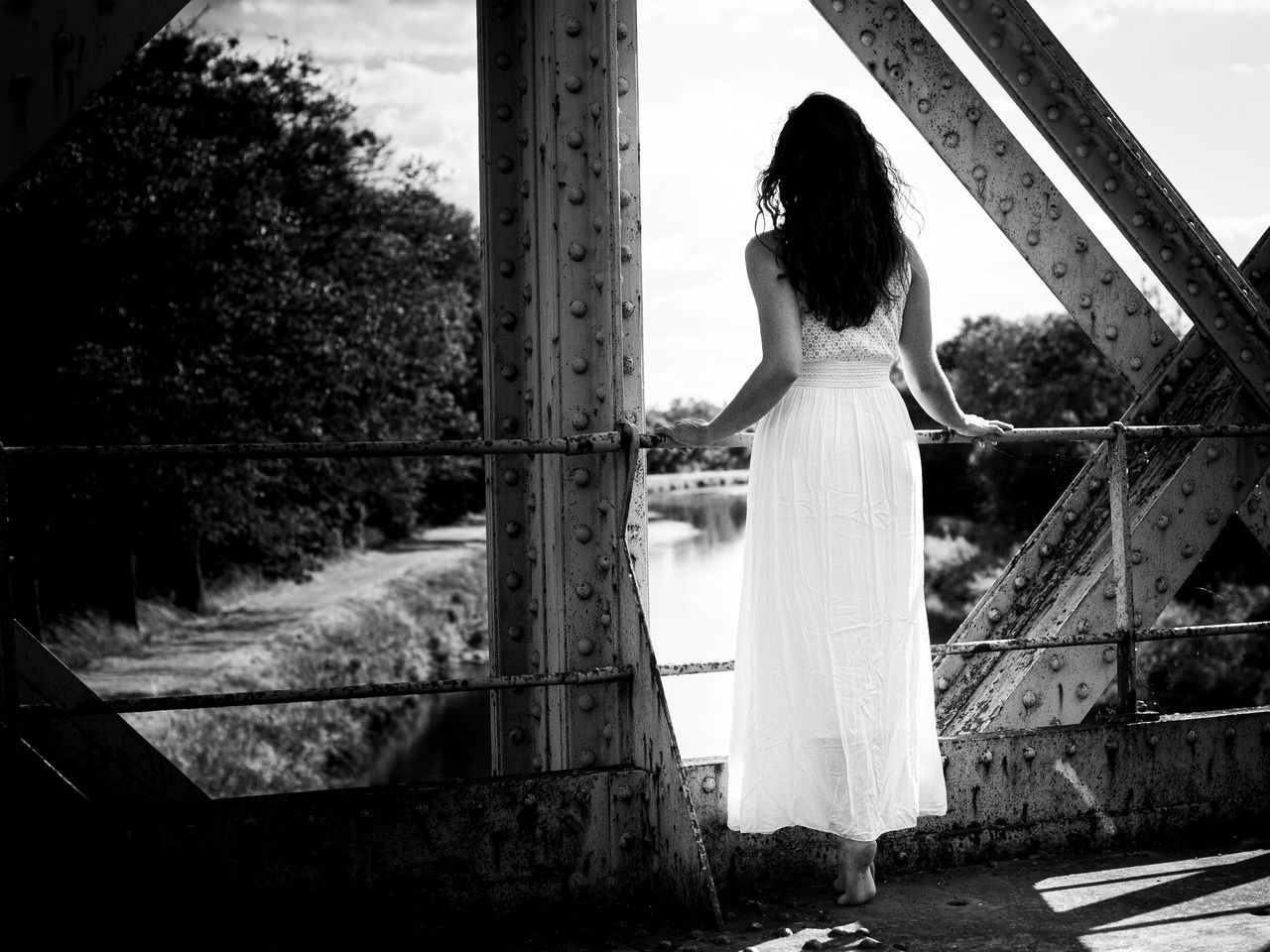 white, wedding dress, black, bride, one person, black and white, women, monochrome photography, monochrome, adult, dress, standing, rear view, architecture, young adult, nature, lifestyles, full length, day, plant, built structure, hairstyle, tree, female, fashion, newlywed, leisure activity, sky, clothing, outdoors, long hair, wedding, darkness, person, photo shoot, looking