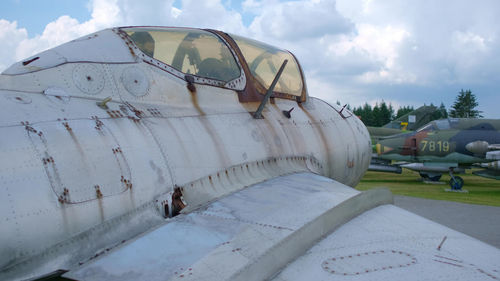 Abandoned airplane on airport runway against sky