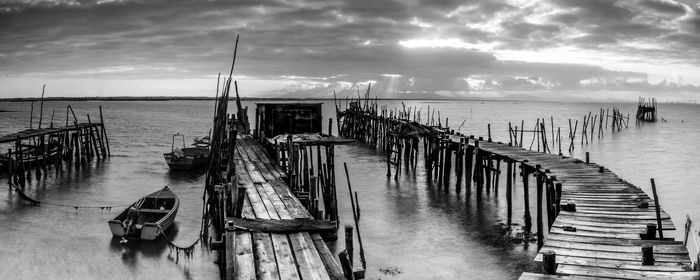 Wooden pier on sea against sky