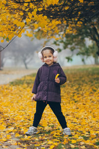 Full length of girl standing on field during autumn