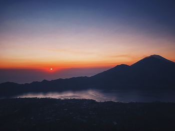 Scenic view of silhouette mountains against sky during sunset