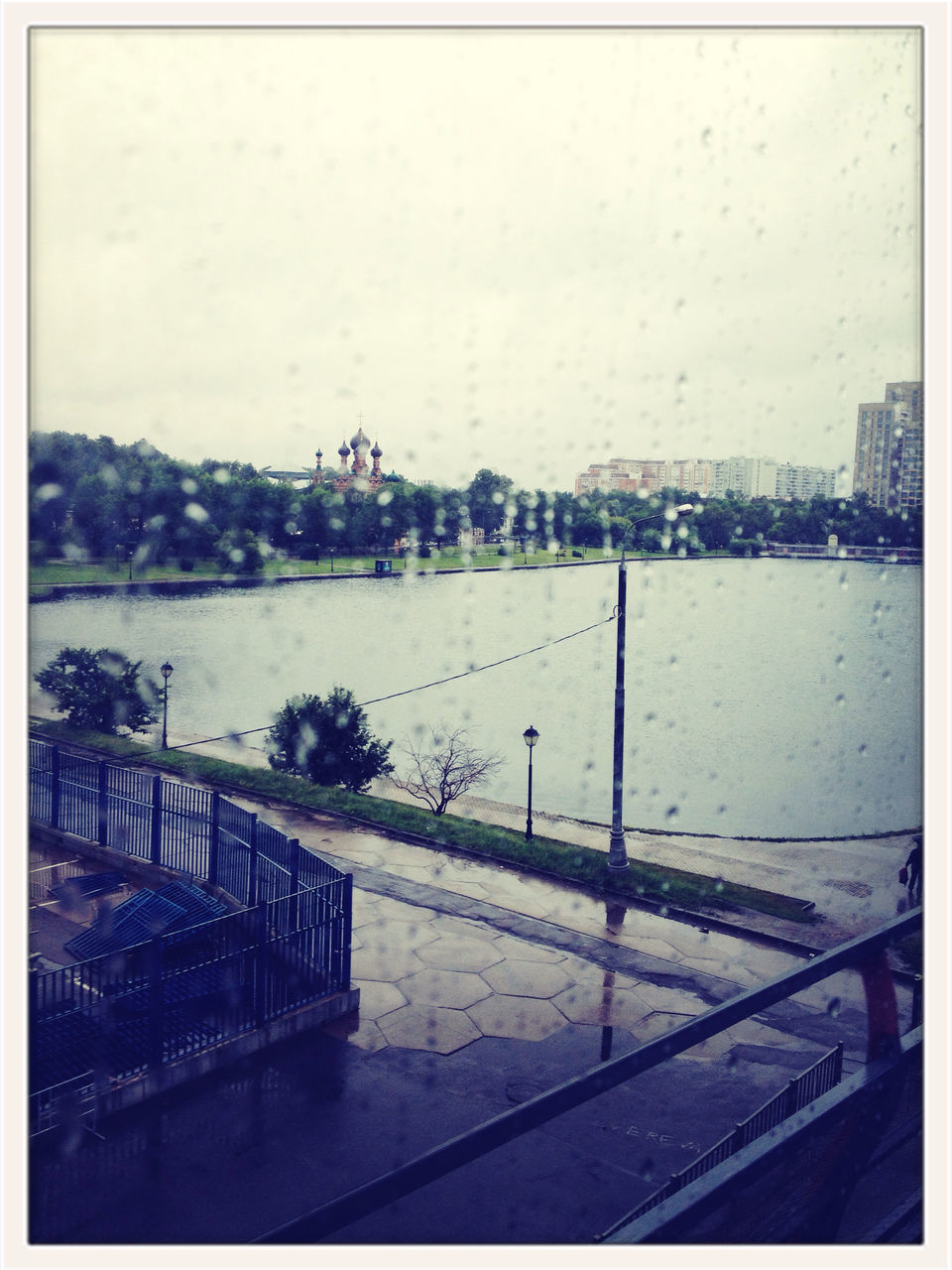 water, transfer print, auto post production filter, architecture, railing, built structure, building exterior, river, season, rain, sky, transparent, glass - material, city, weather, window, clear sky, high angle view, wet, day