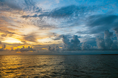 Scenic view of sea against dramatic sky during sunset