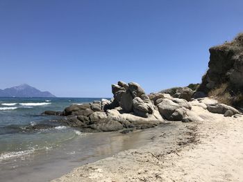 Scenic view of beach against clear blue sky