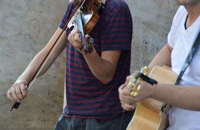 Midsection of performers playing musical equipment