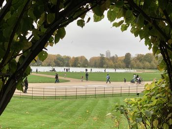 Group of people on grassland against trees