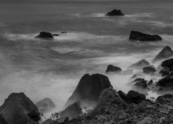 Rock formations in sea against sky