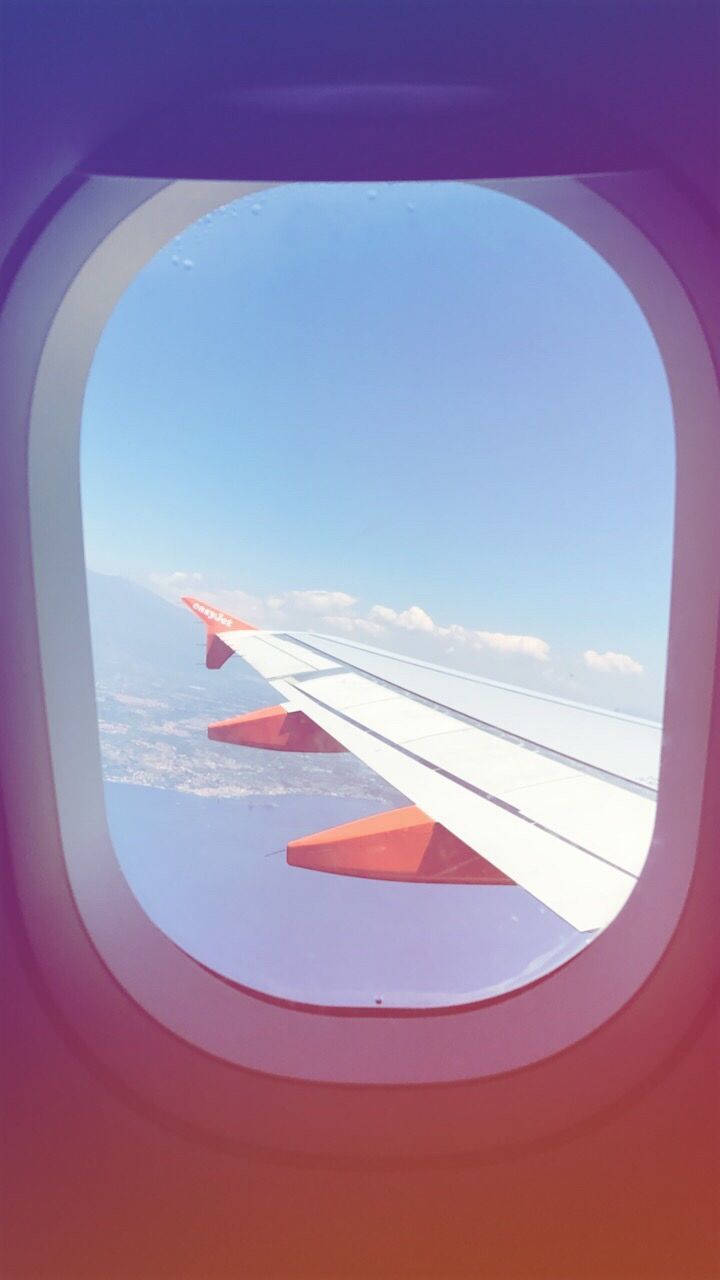 VIEW OF AIRPLANE WING AGAINST SKY SEEN FROM WINDOW