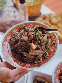 Close-up of hand holding food in bowl