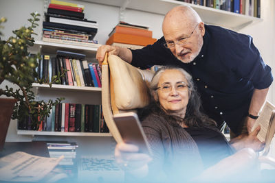 Senior couple taking selfie through mobile phone at home