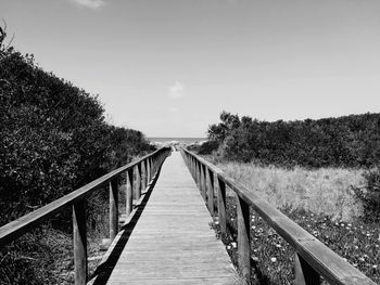 Footbridge over footpath against sky