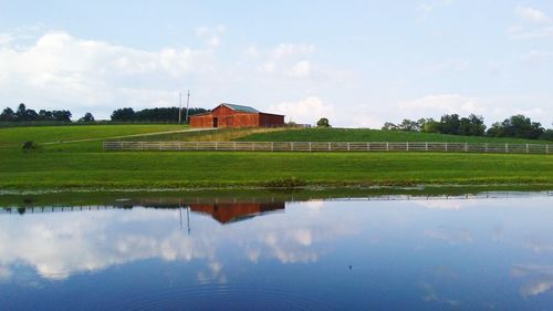 Reflection of houses on field against sky