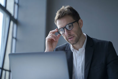 Businessman looking at laptop in office