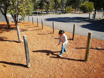 Girl playing with her shadow on roadside