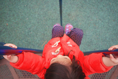 High angle view of girl playing at poles in playground