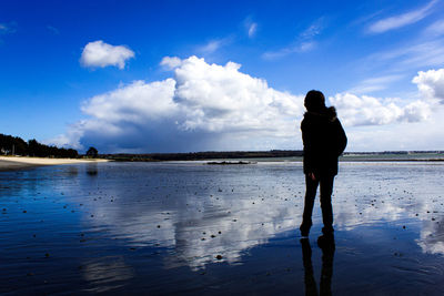 Rear view of silhouette man standing on beach