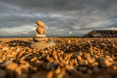 Surface level of pebbles on beach against sky