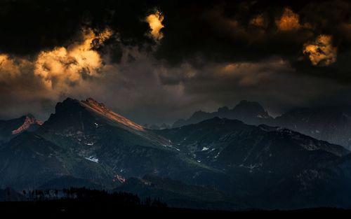 Scenic view of mountains against cloudy sky