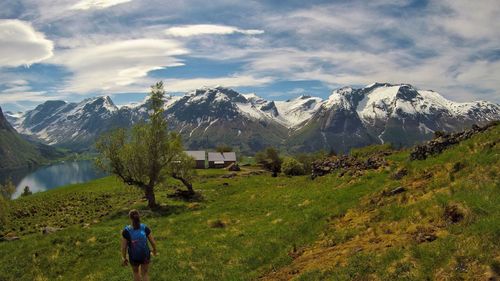 Rear view of people on snowcapped mountain against sky