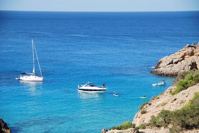 Sailboats sailing in sea against clear sky