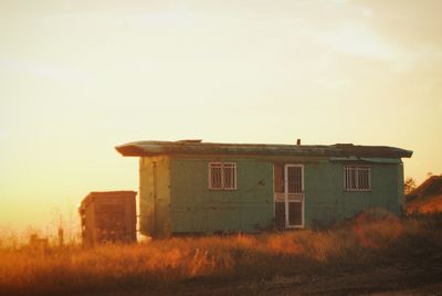 House on grassy field against sky