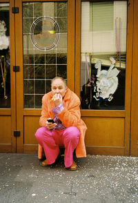 Woman looking away while sitting on window