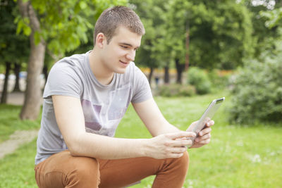 Full length of man using mobile phone in park