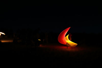 Close-up of illuminated light against sky at night